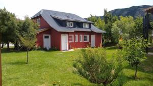 エル・チャルテンにあるAnita´s Houseの緑の芝生のある庭の赤い家