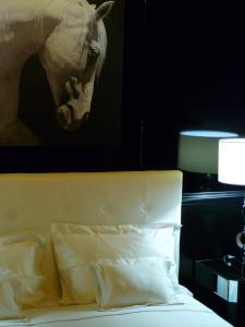 un lit avec une photo d'une tête de cheval sur le mur dans l'établissement Aux Portes d'Honneur, à Cluny