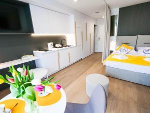 Habitación de hotel con cama, mesa y sillas en MK Apartamenty Młyńska 10, en Kołobrzeg