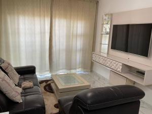 ein Wohnzimmer mit einem Sofa und einem TV in der Unterkunft Lovely 1 Bedroom Unit in an Amazing Golf Estate in Roodepoort