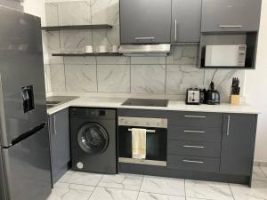 a kitchen with a stove and a washing machine at Lovely 1 Bedroom Unit in an Amazing Golf Estate in Roodepoort