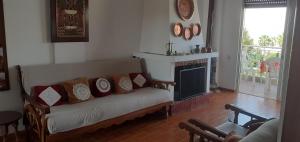 a living room with a couch and a fireplace at Poseidon in Hanioti