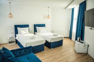 レスコヴァツにあるSky apartmani & spa-Vip Lux DOOのベッド2台とソファのあるリビングルーム +35枚の写真