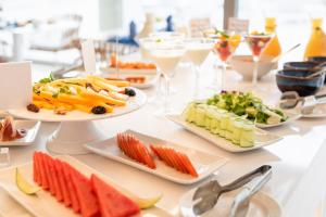 uma mesa com pratos de comida e copos de vinho em Royal Marina Suites Boutique Hotel em Puerto Calero