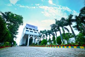 a building with palm trees in front of it at The Imperial Bodhgaya in Bodh Gaya