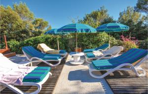 - un ensemble de chaises longues et de parasols sur la terrasse dans l'établissement Nice Home In Signes With Swimming Pool, à Signes