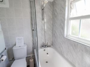 a bathroom with a shower and a toilet and a tub at The Old Post Office in Colwyn Bay