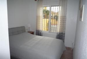 una camera con un letto bianco e una finestra di Villa Nala a Mazarrón