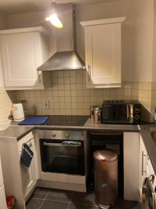 cocina con armarios blancos y fogones en Stay cosy Apartment in Dublin City Centre, en Dublín