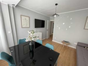 a dining room with a table and blue chairs at Arena Playa Gijón by Flowhome in Gijón