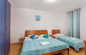 a bedroom with two beds with blue and white sheets at Beautiful Apartment In Pinezici in Pinezici