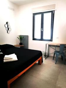 a bedroom with a bed and a table and a window at ANDIRIVIENI☆LECCE ☆CASA VACANZE LECCE in Lecce