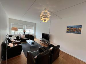 een woonkamer met banken en een flatscreen-tv bij Agata Inn in Frederikssund