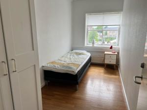 um pequeno quarto com uma cama e uma janela em Agata Inn em Frederikssund