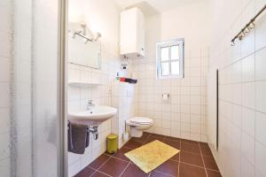 Baño blanco con lavabo y aseo en Gesäuse-Lodge, en Gstatterboden