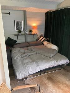 uma cama grande num quarto com cortinas verdes em Lütje Nüst em Rechtsupweg