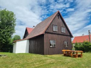 a barn with a picnic table in front of it at Stuga Horni Blatna in Horní Blatná