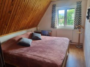 1 dormitorio con 1 cama grande y 2 almohadas en Stuga Horni Blatna, en Horní Blatná