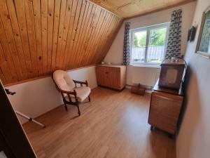an attic room with a chair and a window at Stuga Horni Blatna in Horní Blatná