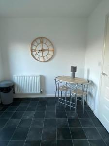 a room with a table and a clock on the wall at Kingfisher House in Mexborough
