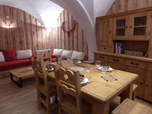 a dining room with a table and a couch at Appartement de charme "Chalet Jacky" suréquipé à 300m des pistes et du centre village in Saint-Martin-de-Belleville