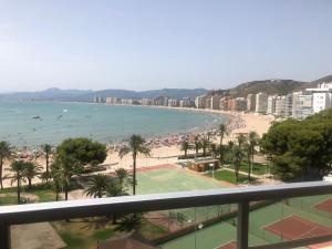 vistas a una playa con palmeras y al océano en Cullera - Apartamento con piscina, tenis y club social, en Cullera