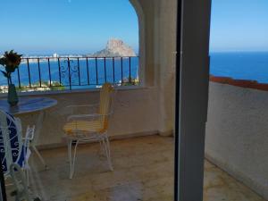 a balcony with a table and chairs and a view of the ocean at Maryvilla 42F in Calpe