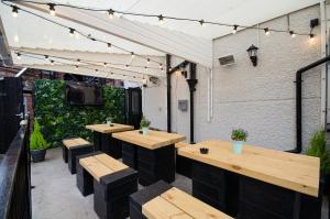 an outdoor patio with wooden tables and benches and a tv at Fox Inn in Guisborough