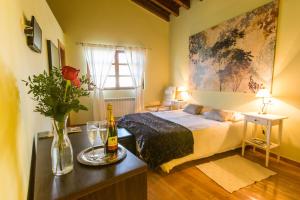 a bedroom with a bed and a bottle of wine at Hotel Rural El Tejar de Miro in Ceadea