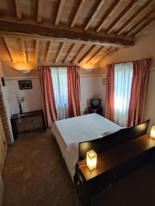 a bedroom with a large bed and two windows at La Locanda del Vino Nobile in Sant'Albino