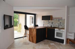 a kitchen with a counter top and a stove at Charmant logis neuf équipé/Piscine/SPA/Sauna/Gym 