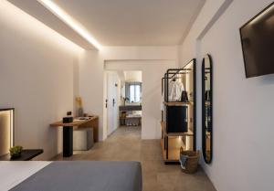 Dormitorio con cama, escritorio y TV en Chora Suites, Premium Key Collection en Skíathos