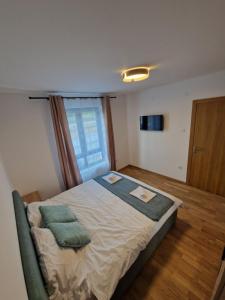 Un dormitorio con una cama con dos almohadas encima. en Nina Apartman 2, en Soko Banja