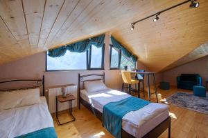 a room with two beds and a window at Hotel GENI Kazbegi in Stepantsminda