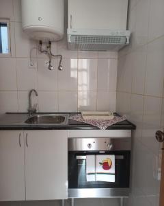 a small kitchen with a stove and a sink at Studios Rossio in Viseu