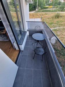 Un balcón con una mesa y un banco en un patio en Nina Apartman 2, en Soko Banja 4 fotos más