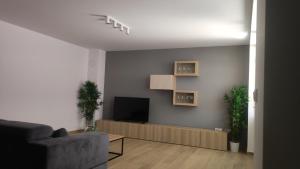 sala de estar con sofá y TV en Parenzo Premium Apartment, en Poreč