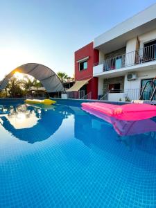 uma piscina com um macarrão de piscina em House of Nissus Hostel em Agia Napa