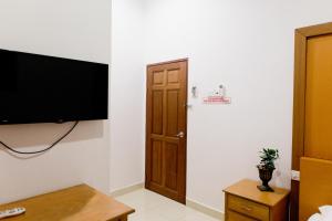 Habitación con TV de pantalla plana y puerta. en Villa Sri Mayang en Kuala Terengganu