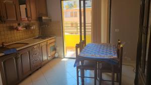 a kitchen with a table and a door to a balcony at Charming Apartment Lushnje in Lushnjë