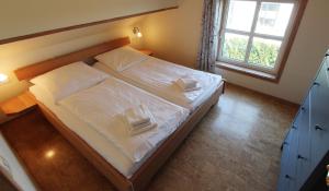 1 dormitorio con 1 cama con sábanas blancas y ventana en Haus Norway Bergen, en Wittenbeck