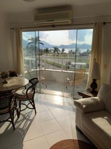 a living room with a couch and a table at Apartamento em Caraguatatuba em Frente a Praia in Caraguatatuba