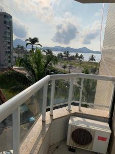 balkon z widokiem na ocean i palmy w obiekcie Apartamento em Caraguatatuba em Frente a Praia w mieście Caraguatatuba