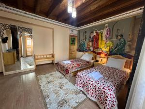 a bedroom with two beds and a mirror at Basilic Boutique Hotel in Bukhara