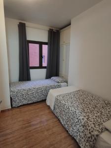 1 Schlafzimmer mit 2 Betten und einem Fenster in der Unterkunft CASA MARIA - Canteras Beach in Las Palmas de Gran Canaria