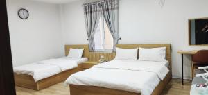 1 dormitorio con 2 camas y ventana en Khách sạn Phúc Thành en Hanoi