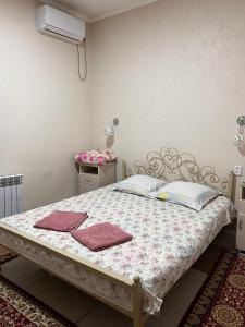 a bedroom with a bed with two towels on it at Bereke Hostel in Shymkent