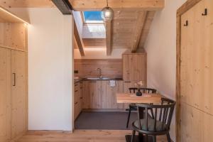 een kleine keuken met een houten tafel en stoelen bij Apartment Reguz in Villnoss