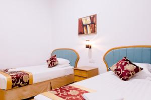 a hotel room with two beds and a table at Villa Sri Mayang in Kuala Terengganu