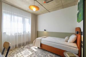 Postel nebo postele na pokoji v ubytování Arche Hotel Wrocław Airport
